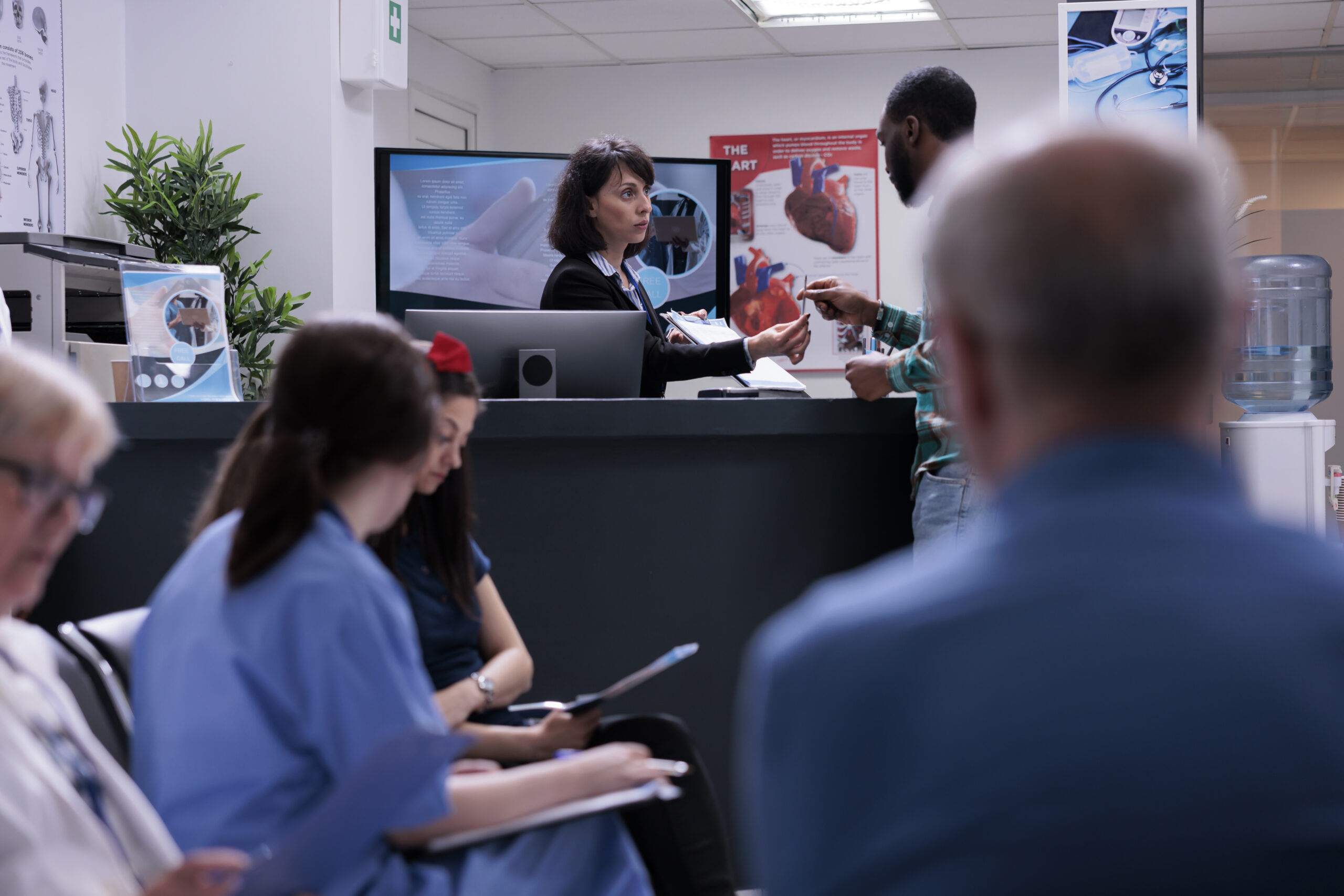 African american patient signing admission form into private clinic at hospital front desk